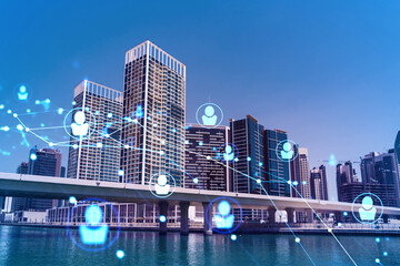 Fototapeta premium Skyscrapers of Dubai business downtown. International hub of trading and financial services. Social network icons hologram, concept of people connection. Double exposure. Dubai Canal waterfront.