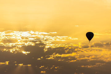 hot air balloon in the sky with orange sunrise clouds