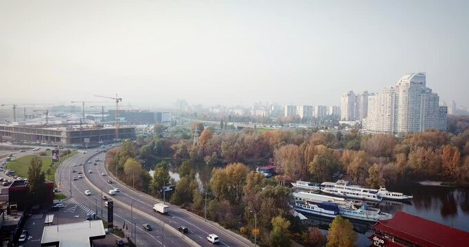 Flight over the highway, along the river and the industrial zone on the other side against the background of a railway bridge autumn, Kiev Ukraine.