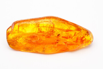 Yellow amber with inclusions on a white background. Natural mineral from ancient petrified resin. Semi-precious color stone for jewelry. Copal. Crystal. Sun stone. Geology. Vintage