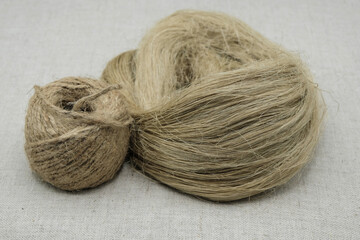 Fibers of natural uncolored flax or hemp, tow, and skein. Gray canvas. Environmentally friendly alternative materials. Growing demand for natural fibers. 