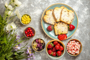 top view yummy cake slices with fruits and candies on light background fruit sweet pie