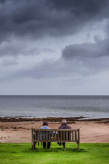 old couple sitting watching the sea