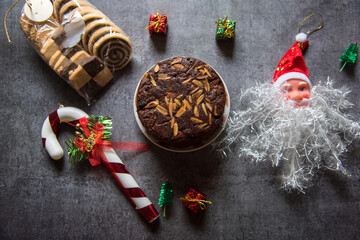Christmas cake, cookies and decorations along with gift boxes on a background