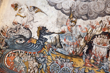 Horizontal shot of one of the frescos of the Romanesque Santa María church showing an infernal scene in Artíes, Vall d’Aran, Lleida, Spain