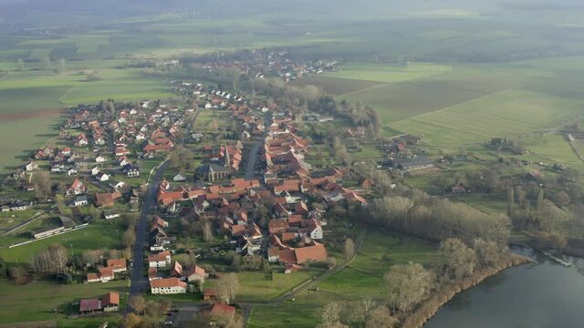 Drone aerial of the typical german village Seeburg located at the Seeburger See on a beautiful Sunday morning. A scenic winter and autumn landscape inviting for a hike with the family in Germany.