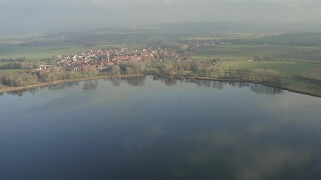 Drone aerial of the typical german village Seeburg located at the Seeburger See on a beautiful Sunday morning. A scenic winter and autumn landscape inviting for a hike with the family in Germany.
