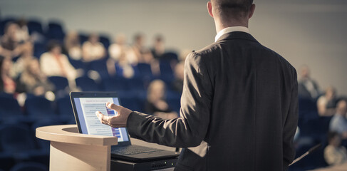 Speaker giving a talk on corporate Business Conference. Audience at the conference hall. Business...