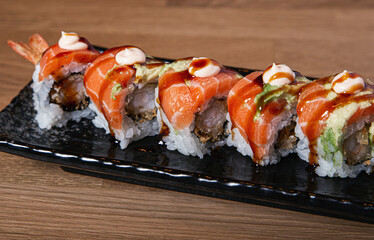 Sushi stuffed with prawn covered with salmon and avocado.
