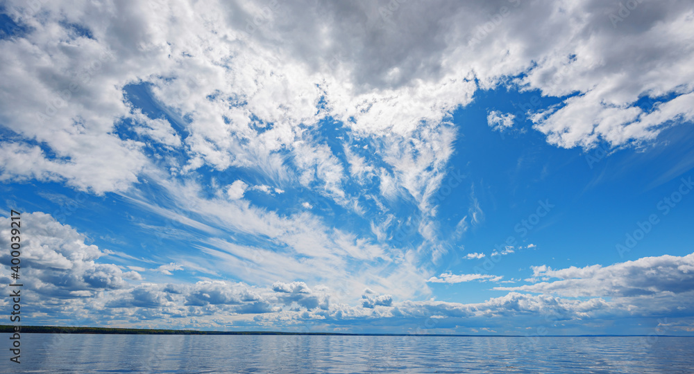 Wall mural panorama of calm lake, kama river blue sky with clouds reflected in the water.