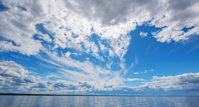 Panorama of calm lake, Kama river blue sky with clouds reflected in the water.