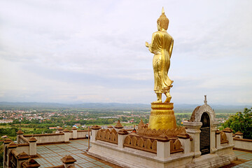 Incredible golden Buddha image in walking posture overlooks the town of Nan, Wat Phra That Khao Noi temple in northern Thailand