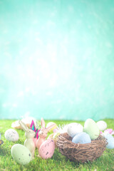 Happy Easter background, spring-time concept. Colorful pastel eggs, nests and bunny toys on  sunny...