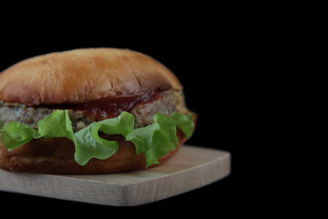 hamburger on wooden desk isolated on black background