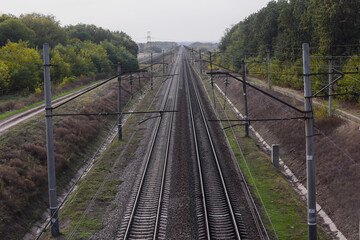 Fototapeta na wymiar Railway, view from the top. The rails go into the distance beyond the horizon. Two pairs of railways run straight. High quality photo