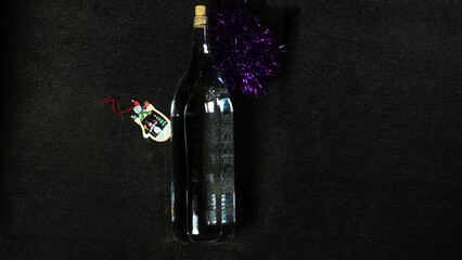 Top view of New Year bottle of homemade strong drink vodka or moonshine on dark background. Still life and festive concepts.