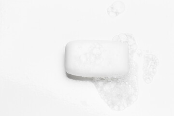 Soap bar and foam on white background