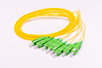short sections of yellow optical cable with green connectors on a white background