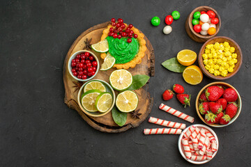 top view yummy creamy cake with candies and fruits on dark desk sweet cookie biscuit