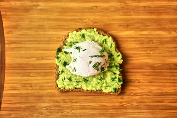 Fototapeta na wymiar A home made sandwich of avocado and a poached egg. Healthy and healthy food. High quality photo