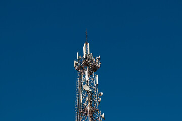 Telecommunication tower with 5G cellular network antenna on vlue sky background