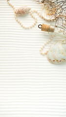 seashells pearls corals on a textured white background . space for text. the view from the top . notepad