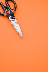 Vertical shot of scissors isolated on pink background. Cutting tool with zigzag blades, copy space