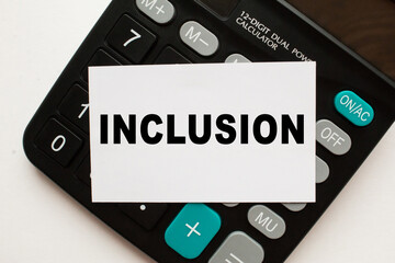card with text INCLUSION on the calculator, white background. business concept