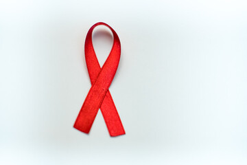 Red ribbon symbol of AIDS and HIV disease. white background 
