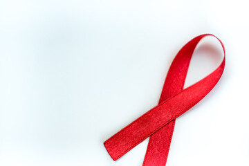 Red ribbon symbol of AIDS and HIV disease. white background 
