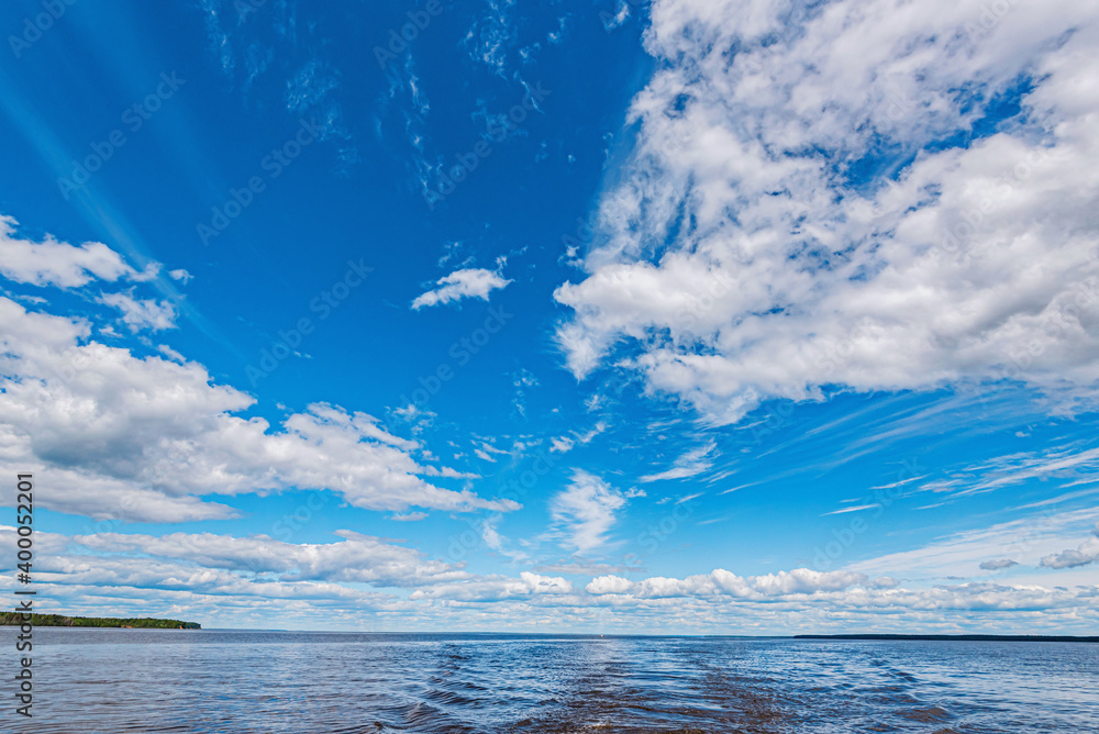 Wall mural panorama of calm lake, kama river blue sky with clouds reflected in the water.