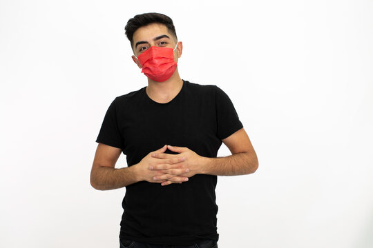 Young male model wearing a red medical face mask. He is wearing a black shirt. Isolated image and white background.