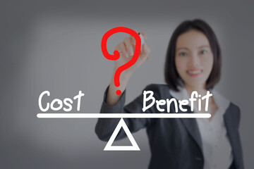 businesswoman  writing cost and benefit compare on balance bar