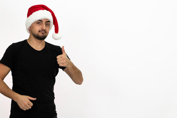 Fototapeta na wymiar Young man wearing a Santa hat. He is wearing a black shirt. Isolated image white background.