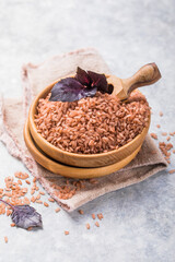 Brown Unpolished rice in wooden bowl. Long grain rice background.
