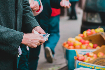 Man holdings and counting his money to pay for the product which sells on the city’s street....