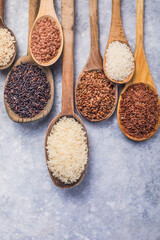 Organic white Jasmine rice, unpolished black and brown rice, Riceberry  in wooden spoons