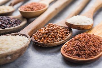 Organic white Jasmine rice, unpolished black and brown rice, Riceberry  in wooden spoons