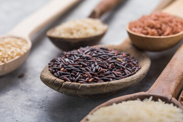 Organic white Jasmine rice, unpolished black and brown rice, Riceberry  in wooden spoons