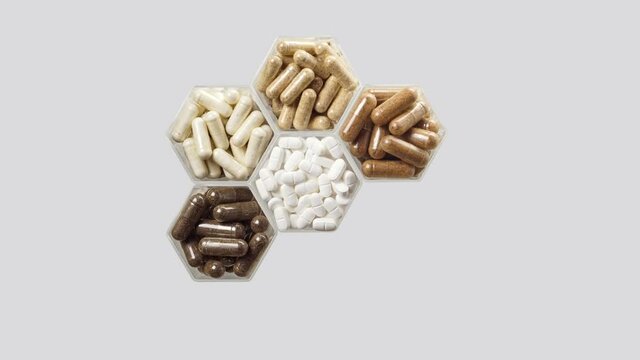 Various pills and capsules in hexagonal jars appear on a grey background