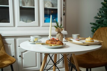 European desserts in a cafe on the New Year's table. Croissant, meringue, tart, coffee.