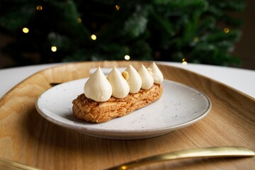 Eclair with meringues on a plate. European desserts on the New Year's table.