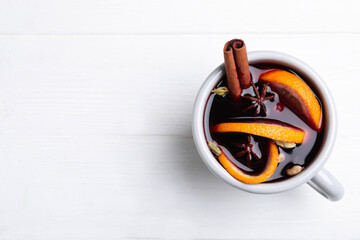 Aromatic mulled wine on white wooden table, top view. Space for text