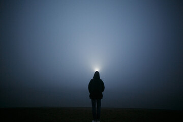 Girl at night in the fog.