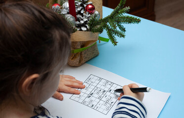 Child solves Japanese crossword sudoku