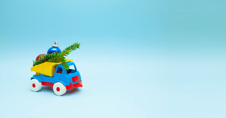 Children's toy truck filled with Christmas tree decorations. New year concept. Machines
and on a blue background