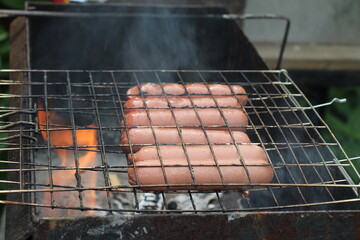 Barbecue with sausages grilling over a fire	