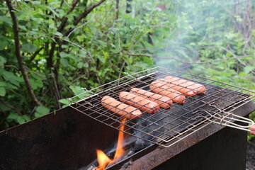 Barbecue with sausages grilling over a fire	
