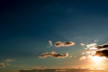 Cielo con nubes a contra luz con colores azul, amarillo, y naranja