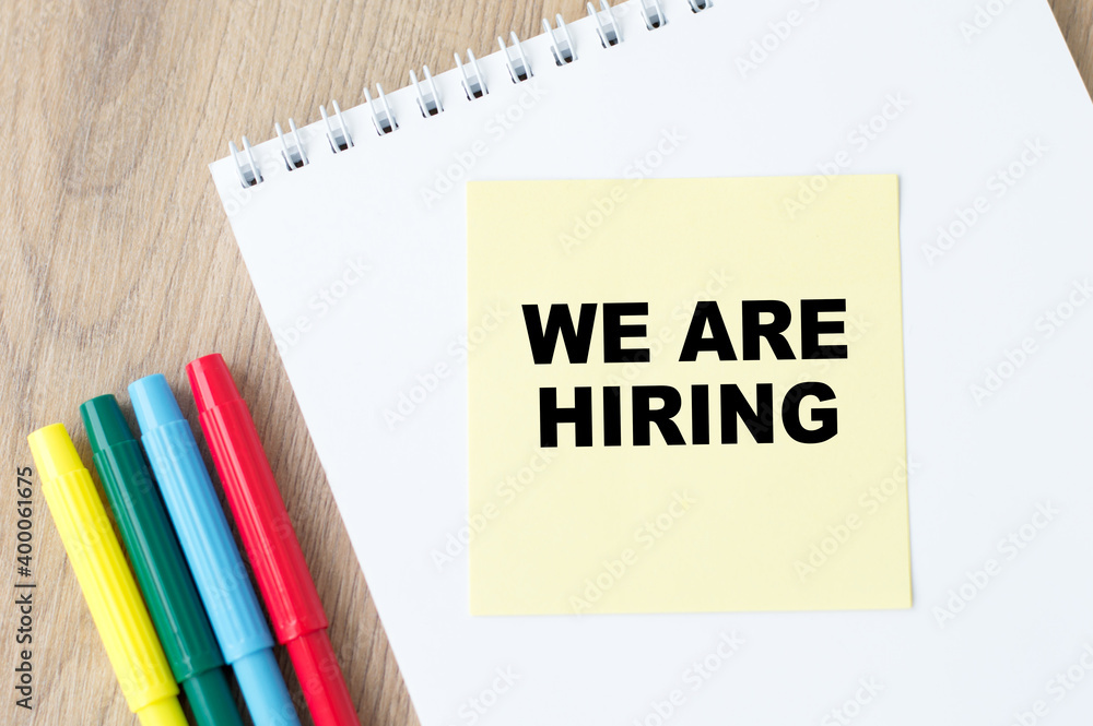 Poster yellow card notepad with text we're hiring on the desktop